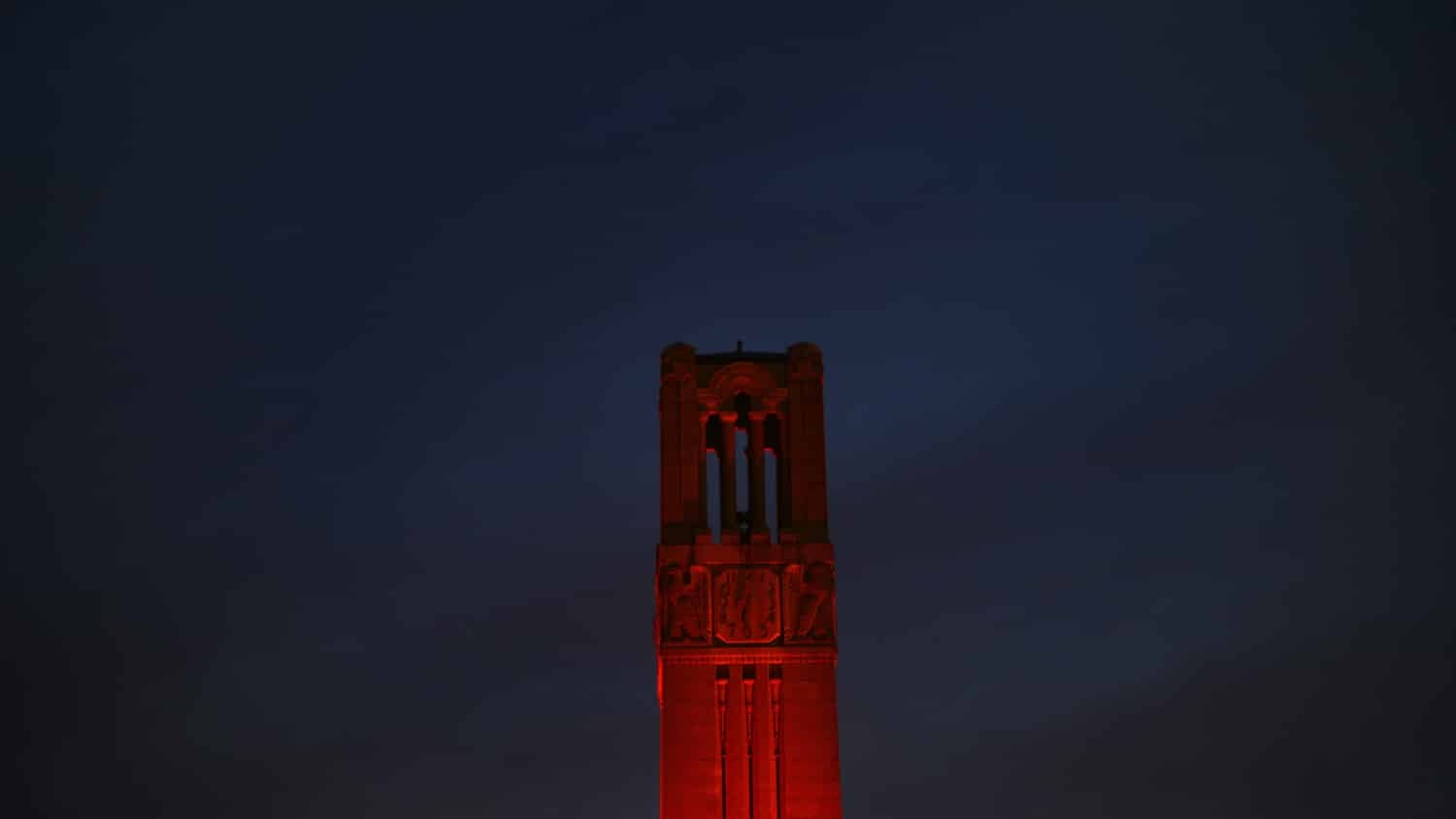 Belltower lit red against a night sky