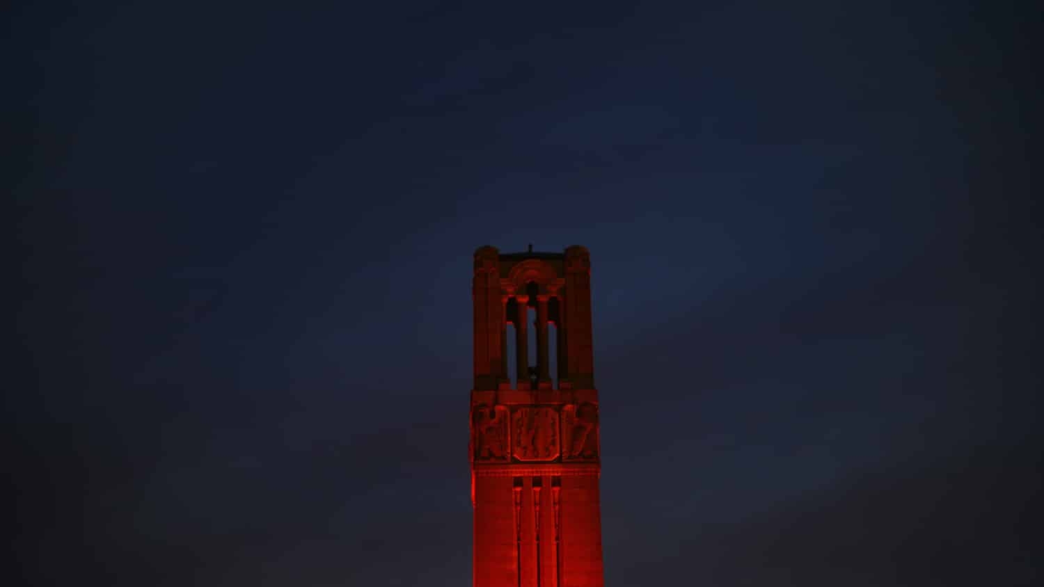 Belltower lit red against a night sky